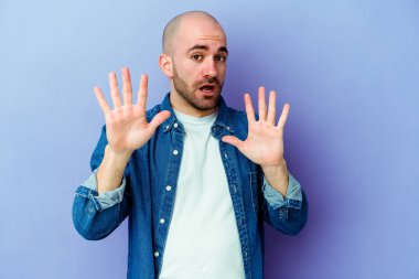 Mor arka planda izole genç beyaz adam yakın bir tehlike nedeniyle şoka uğruyor.