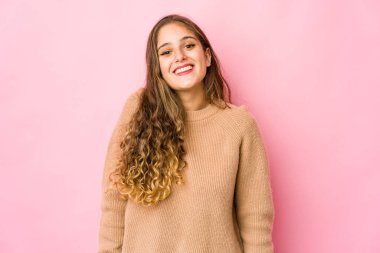 Genç beyaz kadın gülüyor ve gözlerini kapıyor, rahatlamış ve mutlu hissediyor..