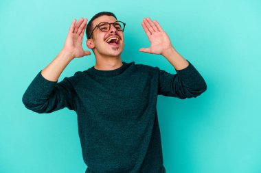 Mavi arka planda izole edilmiş beyaz bir adam heyecanlı bir şekilde bağırıyor..