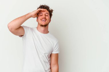 Beyaz arka planda izole olmuş genç beyaz bir adam gülüyor, kaygısız, doğal bir duygu..