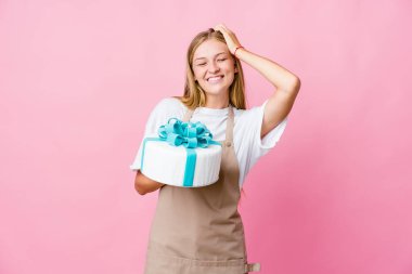 Genç Rus fırıncı kadın elinde lezzetli bir pasta tutarken mutlu bir şekilde ellerini başının üstünde tutuyor. Mutluluk kavramı.