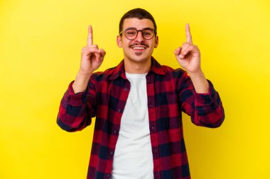 Sarı arka planda izole edilmiş beyaz bir adam iki parmağı da boş bir alan gösteriyor..