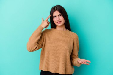 Mavi arka planda izole edilmiş beyaz bir kadın işaret parmağıyla hayal kırıklığı jesti yapıyor..