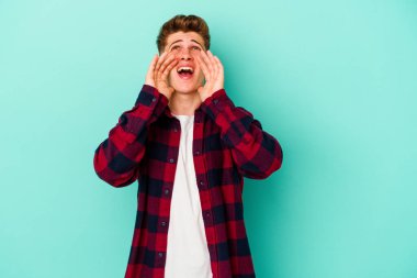 Mavi arka planda izole edilmiş beyaz bir adam heyecanlı bir şekilde bağırıyor..