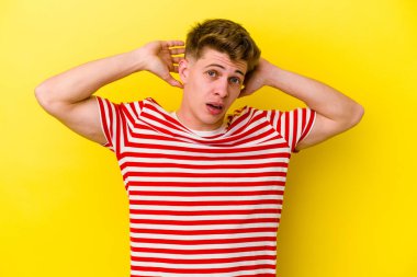 Sarı arka planda izole edilmiş genç beyaz bir adam çığlık atıyor, çok heyecanlı, tutkulu, bir şeyden memnun..