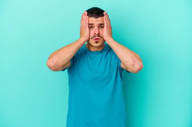 Mavi arka planda izole genç beyaz adam şok oldu, o önemli bir toplantı hatırladı.