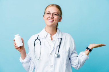 Genç Rus doktor elinde ilaç şişesi tutan kadın kollarıyla ölçeği yapıyor, mutlu ve kendinden emin hissediyor..