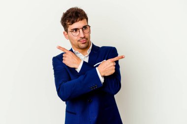 Beyaz arka plan noktalarında izole genç beyaz adam, iki seçenek arasında seçim yapmaya çalışıyor.