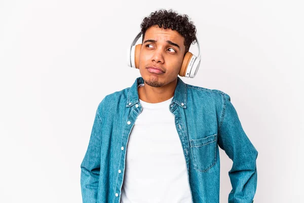 若いアフリカ系アメリカ人の男性がヘッドフォンで音楽を聴いて孤立混乱し 疑わしいと感じている — ストック写真