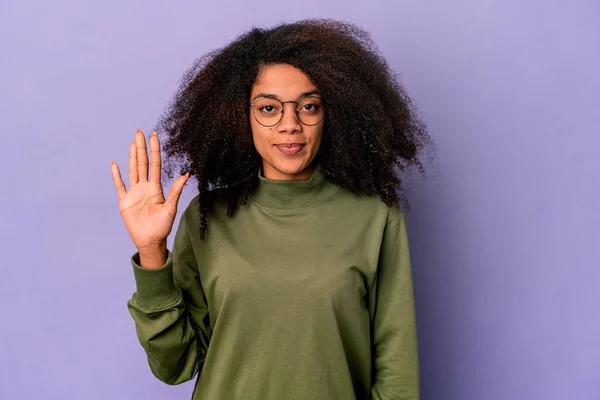 年轻的非洲裔美国卷曲女子 被紫色背景隔离 面带微笑 高高兴兴地露出五号手指 — 图库照片