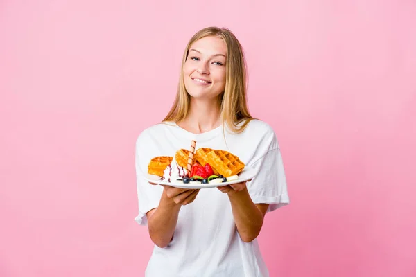 年轻的俄罗斯女人正在吃着一个单独的华夫饼 手里拿着一个有手掌的东西 主动提出要拍照 — 图库照片