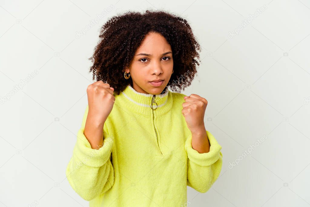 Young african american mixed race woman isolated showing fist to camera, aggressive facial expression.