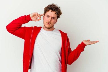 Beyaz arka planda izole edilmiş genç beyaz bir adam elinde bir ürün tutuyor ve.