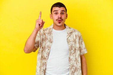 Sarı arka planda izole edilmiş, ağzı açık, üst tarafı gösteren beyaz bir adam..