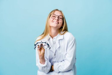Genç Rus optometrist kadın mavi üzerine gülüyor ve eğleniyor..