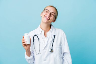 Genç Rus doktor elinde ilaç şişesi, mavi, gevşemiş ve mutlu kahkahalar atan, boynunda dişlerini gösteren bir kadın..