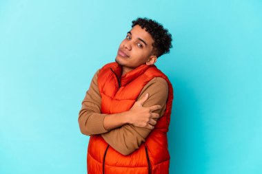 Genç Afro-Amerikan kıvırcık adamı mavi kucaklamalarda yalnız, kaygısız ve mutlu..
