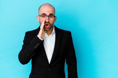 Mavi arka planda izole genç beyaz adam gizli bir sıcak fren haberi söylüyor ve yana bakıyor