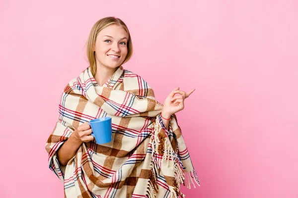 Młoda Rosjanka Owinięta Koc Pijąca Kawę Uśmiechnięta Wskazująca Bok Pokazująca — Zdjęcie stockowe