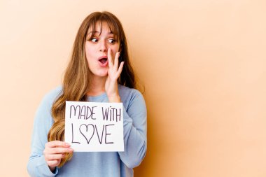 Elinde aşk levhasıyla izole edilmiş beyaz bir kadın gizli bir sıcak fren haberinin olduğunu söylüyor.