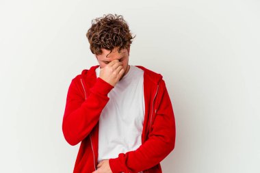 Beyaz arka planda izole olmuş genç beyaz bir adam başı ağrıyor, yüzüne dokunuyor..