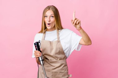 Genç Rus aşçı kadın elinde elektrikli mikser tutuyor. Bir fikri var, ilham verici bir kavram..