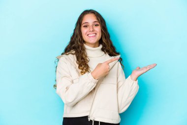 Kafkasyalı kıvırcık saçlı genç kadın, avucunun içinde bir fotokopi alanı tutarken heyecanlı..