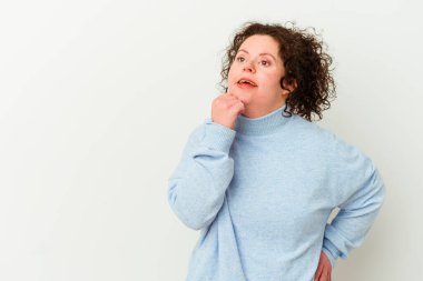 Down sendromlu bir kadın şüpheli ve şüpheci bir ifadeyle yan bakıyor..