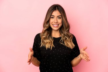 Kafkasyalı genç kadın iki eliyle bir şey tutuyor, ürün sunumu..