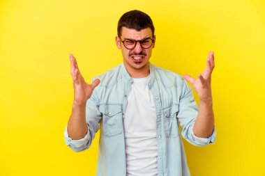 Sarı arka planda izole edilmiş beyaz bir adam öfkeyle bağırıyor..