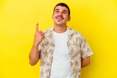 Sarı arka planda izole edilmiş beyaz bir adam iki parmağı da boş bir alan gösteriyor..