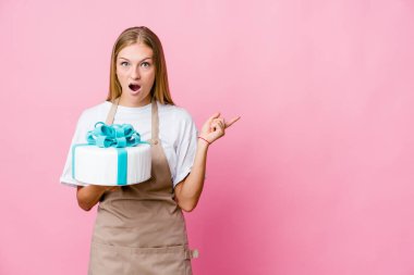 Genç Rus fırıncı kadın elinde leziz bir pasta tutuyor.