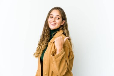 Genç beyaz kadın başparmağıyla işaret ediyor, gülüyor ve kaygısız..