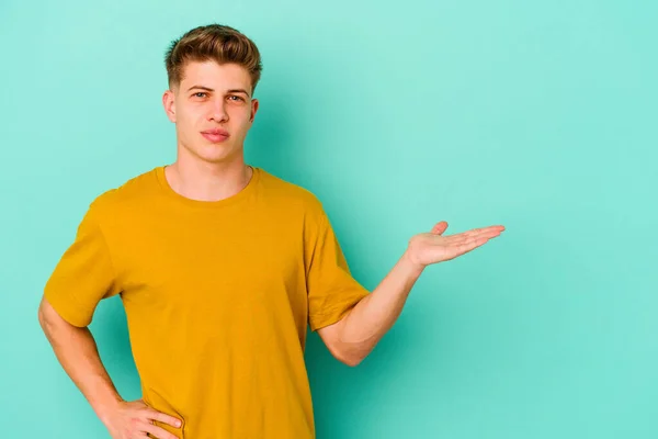 Young Caucasian Man Isolated Blue Background Showing Copy Space Palm — Stock Photo, Image