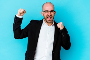 Genç beyaz, kel adam mavi arka planda izole edilmiş dans ediyor ve eğleniyor..