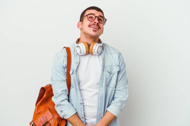 Beyaz arka planda müzik dinleyen beyaz tenli genç bir öğrenci amaçlarına ve amaçlarına ulaşma hayali kuruyor.