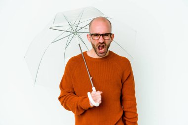 Elinde şemsiyesi olan genç kel bir adam öfkeli ve agresif çığlıklar atıyor..