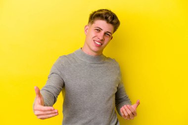 Sarı arka planda izole edilmiş beyaz bir genç hoş bir yüz ifadesi sergiliyor..