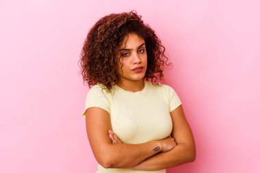 Genç Afrikalı Amerikalı kadın pembe arka planda izole edilmiş şüpheli, belirsiz, seni muayene ediyor..