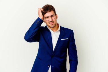 Beyaz arka planda izole edilmiş genç beyaz bir adam bir şeyi unutuyor. Alnına avuç içi ve kapalı gözlerle vuruyor..