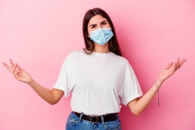 Pembe arka planda izole edilmiş virüs maskesi takan beyaz bir kadın hoş bir yüz ifadesi sergiliyor..