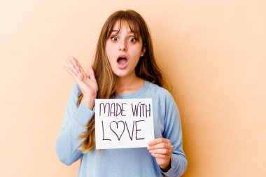 Elinde aşk levhası olan beyaz bir kadın var. Şaşırmış ve şok olmuş..