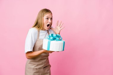 Genç Rus fırıncı elinde lezzetli bir pasta tutan kadın yüksek sesle bağırıyor, gözleri açık ve elleri gergin tutuyor..