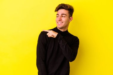 Sarı arka planda izole edilmiş genç beyaz adam gülümseyen, neşeli ve keyifli görünüyor..