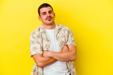 Sarı arka planda izole edilmiş, sıkılmış, yorgun ve dinlenmeye ihtiyacı olan genç beyaz bir adam..