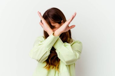 Beyaz arka planda izole edilmiş beyaz tenli hoş bir kadın iki kolu çapraz tutuyor, inkar kavramı..