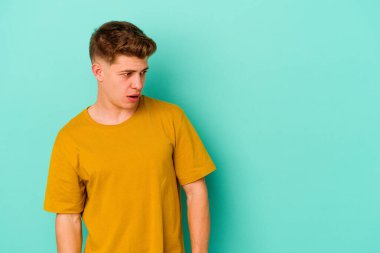 Kafkasyalı genç adam mavi arka planda izole edilmişti. Gördüğü bir şey yüzünden şok olmuştu..