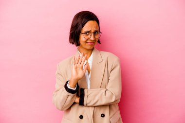 Genç iş kadını, pembe arka planda izole edilmiş, tiksinti gösteren birini reddediyor..
