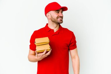 Beyaz arka planda izole edilmiş beyaz tenli teslimatçı gülümseyen, neşeli ve keyifli görünüyor..