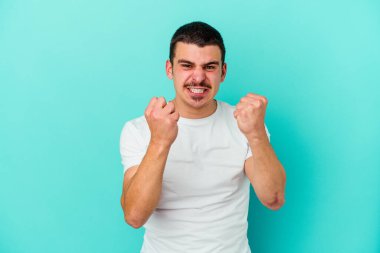 Mavi arka planda izole edilmiş genç beyaz adam gergin elleriyle çığlık atıyor..